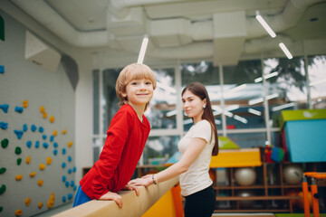 Kids doing balance beam gymnastics exercises in gym at kindergarten or elementary school. Children sport and fitness concept