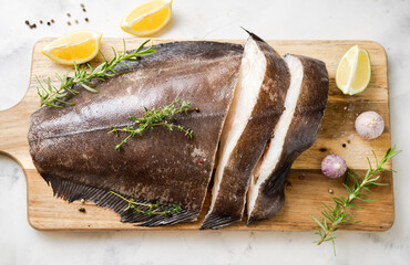 Wall Mural - Close up of fresh raw halibut fish on wodden board with herbs and lemon. Top view. Omega 3 fats good for mental clarity. Brain food