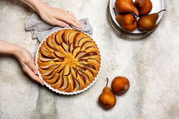 Poster - Woman's hand holding  just made pie with brown pears. Light background, copy space. Copy space.