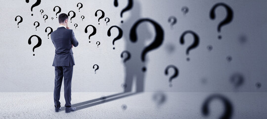 Poster - Thinking young european businessman standing in concete interior with question mark sketch. Solution and brainstorm concept.