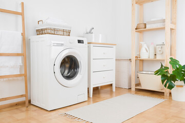 Washing machine in vintage laundry room interior with wooden furniture