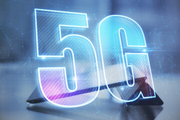 Leinwandbilder - Close up of desktop with tablet and abstract glowing 5G hologram on dark blue background. Wireless infomation and future technology concept. Double exposure.