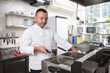 Professional chef using fryer, working at his kitchen, copy space