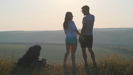 The couple of travelers standing on the mountain top