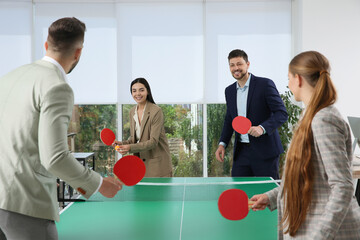 Canvas Print - Business people playing ping pong in office