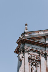 Wall Mural - Low angle of a side part of St. Peter with statue under blue sunny sky in Vatican City, Rome, Italy