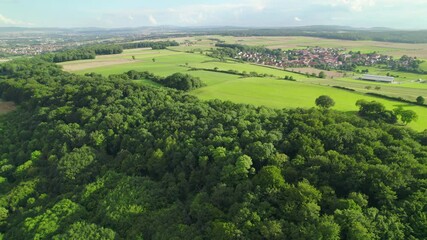 Poster - Aerial view of a German village surrounded by meadows, farmland and forest. A circular moving drone shot towards the town. Middle German Countryside.