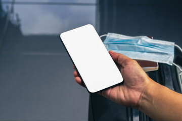 Wall Mural - hand holding of a smartphone with suitcase background. close-up photo. space for text. technology an