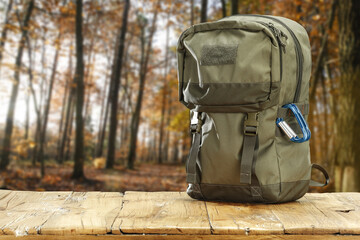 Wall Mural - Autumn trip and green backpack on wooden desk. Free space for your decoration. 