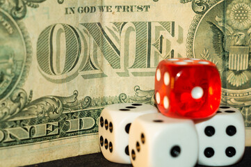 Sticker - Closeup shot of a pile of dice in front of a dollar bill- gambling, casino concept