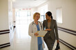 © KOTO - Doctor and businesswoman walking in hospital corridor