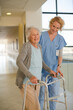 © KOTO - Nurse helping senior patient with walker in hospital corridor