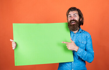 Wall Mural - look over there. brutal caucasian hipster hold paper shit, copy space. human emotions. unshaven guy with groomed long hair. barbershop and hairdresser. male beauty and fashion. happy bearded man