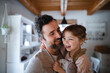 © Halfpoint - Mature father with small daughter standing indoors at home, holding and hugging.