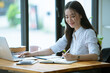 © Morakot - Portrait of Beautiful businesswoman sitting at desk and working with laptop computer.