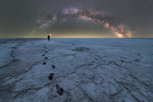 Traveler Standing In Dry Salt Lagoon Against Night Starry Sky
