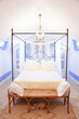 Chandelier over four poster bed in luxury bedroom