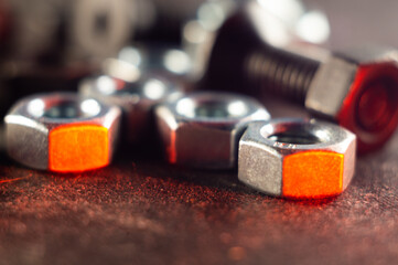 Wall Mural - Closeup shot of metal nuts and screws in the red light