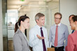 © KOTO - Business people talking in office hallway