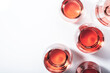 Rose wine glasses on white background. Wine tasting, top view, negative space