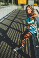 Wall Mural - Woman Taking A Break After Training On A Bridge