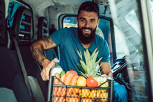 Young Bearded Man Is Driving Delivery Van. He Is Working In Everyday Or Daily Home Delivery Service.