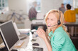 © KOTO - Businesswoman talking on headset at desk