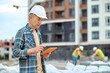 © zinkevych - Handsome concentrated engineer reading an email on his gadget