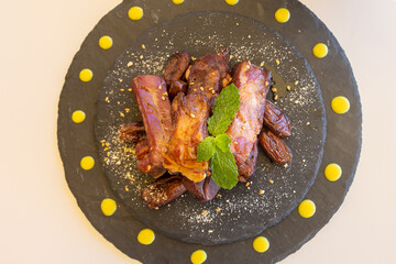 Wall Mural - Top view shot of pork ribs with smoked paprika decorated with mint on the ground serving board