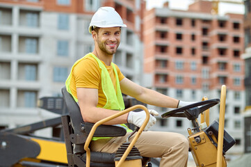 Wall Mural - Worker in a hardhat at the steering wheel of a vehicle