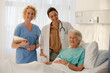 © KOTO - Doctor, nurse and senior patient smiling in hospital room