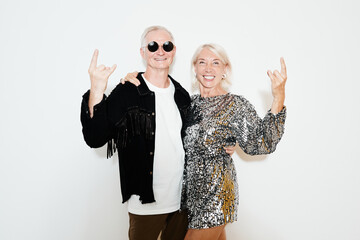 Wall Mural - Waist up portrait of glamorous mature couple posing against white background at party, shot with flash