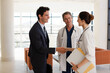 © KOTO - Doctor and businessman handshaking in hospital lobby