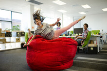 Businesswoman Playing In Beanbag Chair In Office