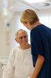 © KOTO - Nurse reading older patient's medical bracelet in hospital