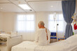 © KOTO - Older patient wearing gown in hospital room