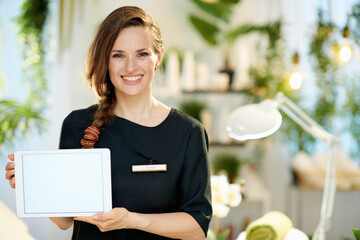 happy woman employee in beauty studio showing tablet PC