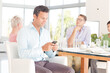 © KOTO - Businessman using cell phone in office