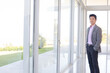 © KOTO - Businessman standing at office window