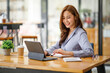 © David - Portrait of smiling beautiful business asian woman working in modern office desk using tablet laptop computer, Business people employee freelance online marketing e-commerce telemarketing concept.