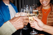 © Seventyfour - Close up of young people clinking champagne glasses at party, shot with flash, copy space