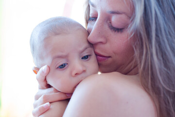 Bare chested mother holding baby boy