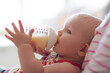 Baby girl drinking from bottle