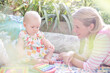Mother and baby girl playing with xylophone outdoors