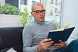 © tetxu - mature man reading on the sofa at home