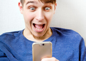 Canvas Print - Surprised Young Man with a Phone