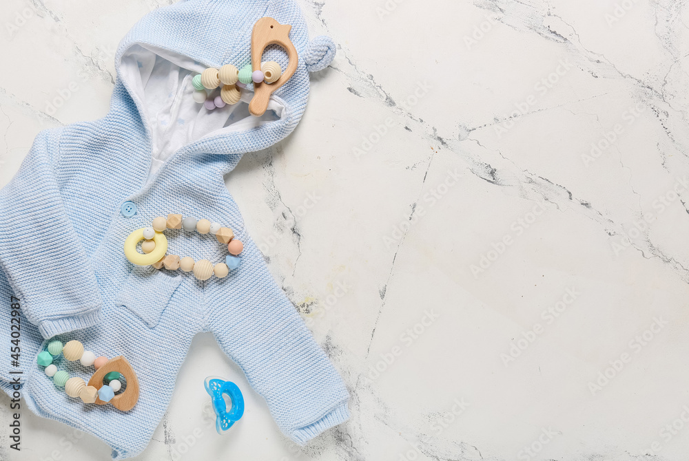 Stylish baby clothes with toys on white background