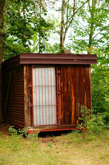 Wall Mural - Wooden hut in front of green trees