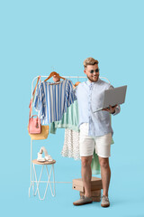 Wall Mural - Male stylist showing clothes to client online on color background