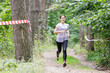 © skumer - Young wet sportswoman running on her course in obstacle race after crossing a river